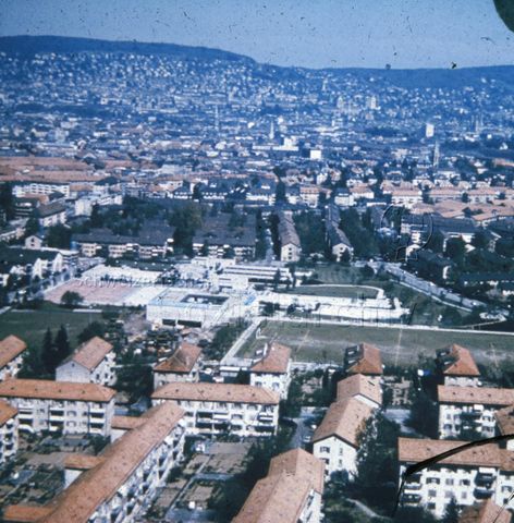 "Freizeitanlagen, Gemeinschaftszentren: Überblick Heuried, Zürich" - Blick auf die Anlage mit Sportplätzen und Robinsonspielplatz sowie der näheren Umgebung; um 1960