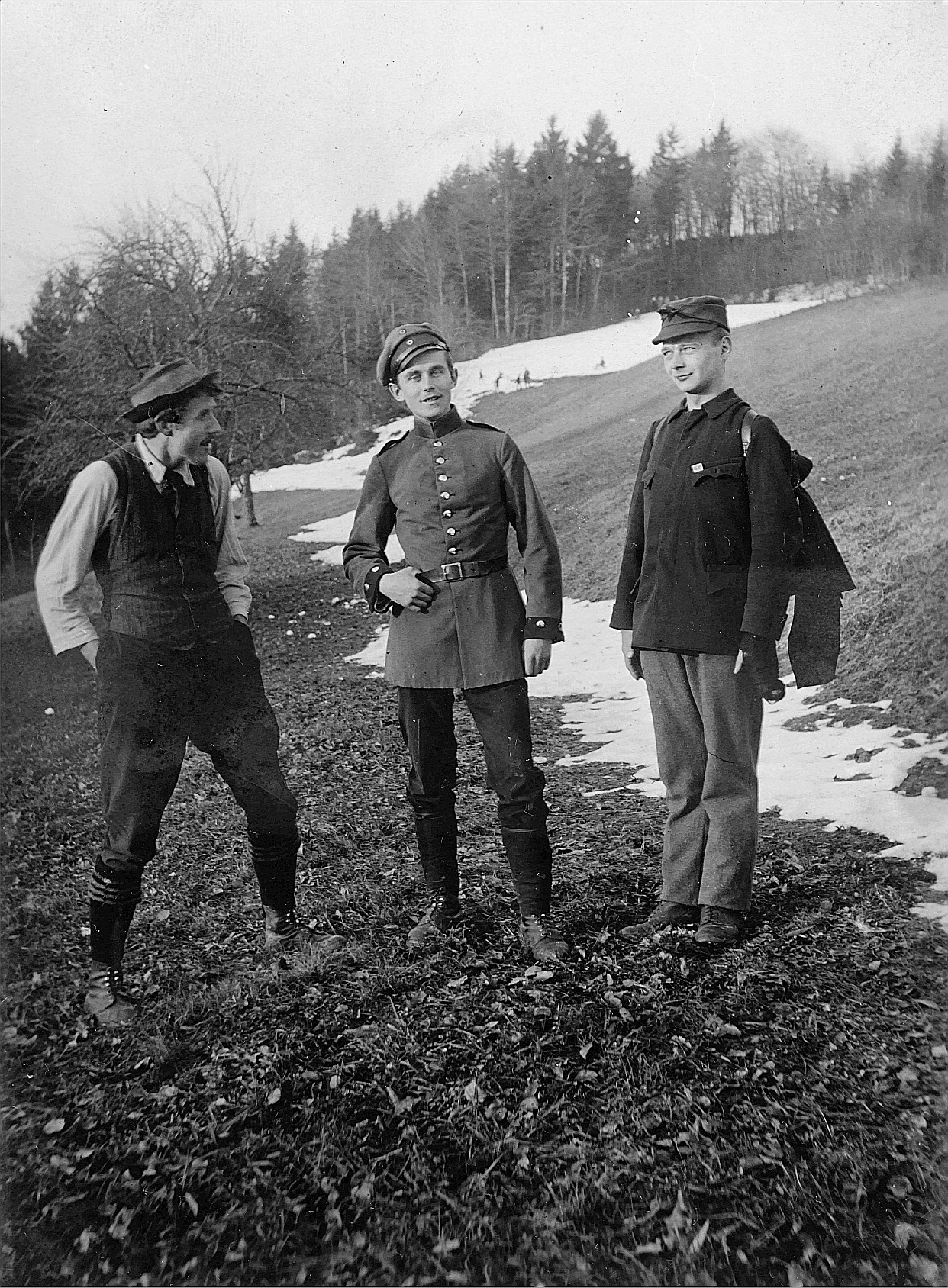 Gruppenporträt dreier Wandervögel auf der zum Teil verschneiten Wiese, ein Wandervogel uniformiert (Militäruniform?) (1918)