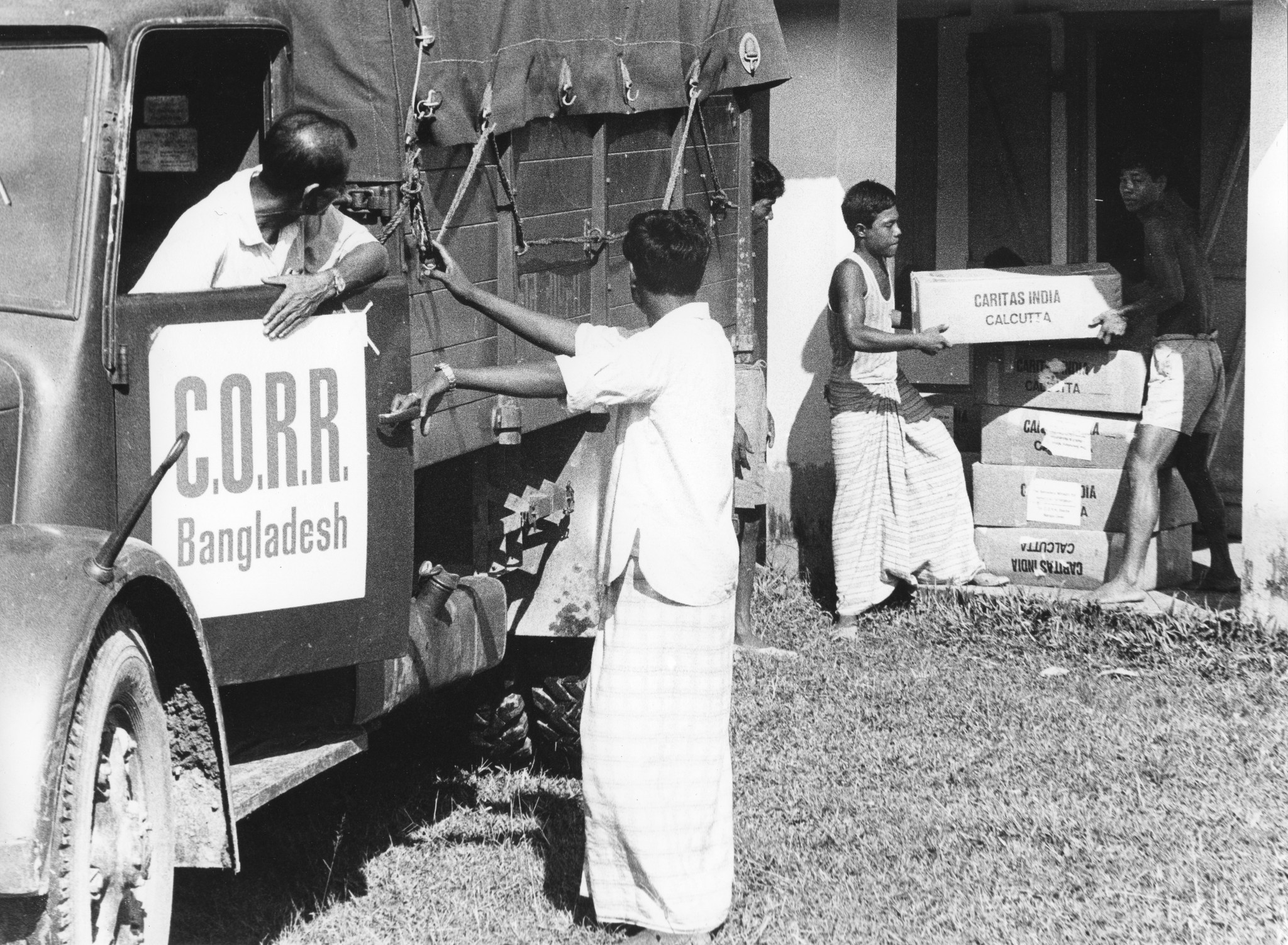 "Bangladesh: Swiss Truck Team Oktober 1972"; Einheimische beladen einen Lastwagen mit Hilfsgütern