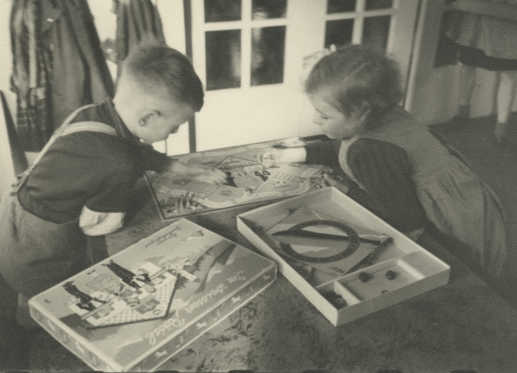 "Köln 1949 - Beschäftigung im Hort"; zwei Kinder spielen an einem Tisch ein Spiel