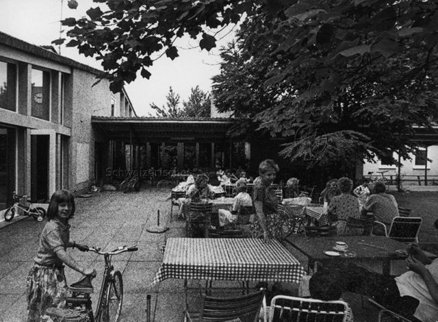 "Gemeinschaftszentrum Bachwiesen", Zürich - Besuchende sitzen draussen; um 1980