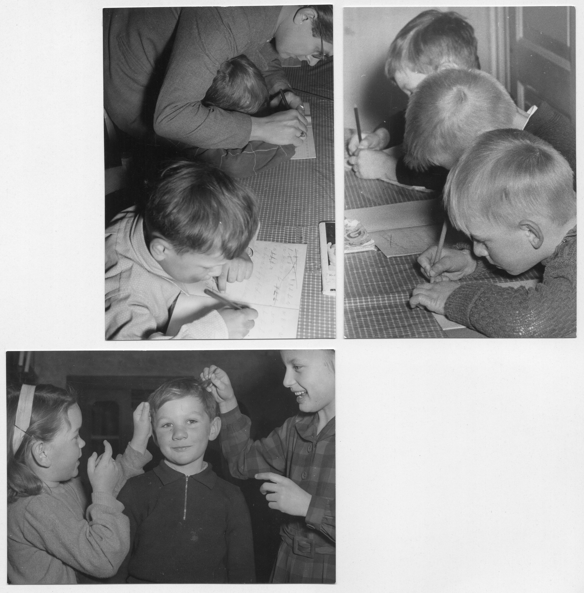 Kinder schreiben Schönschrift; zwei Mädchen zupfen einem Knaben an den Haaren