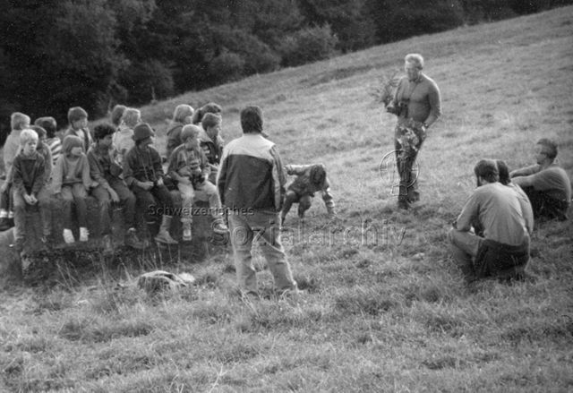 "bei den Jägern" - Gruppe von Kindern und Betreuern hört Jäger zu; um 1990