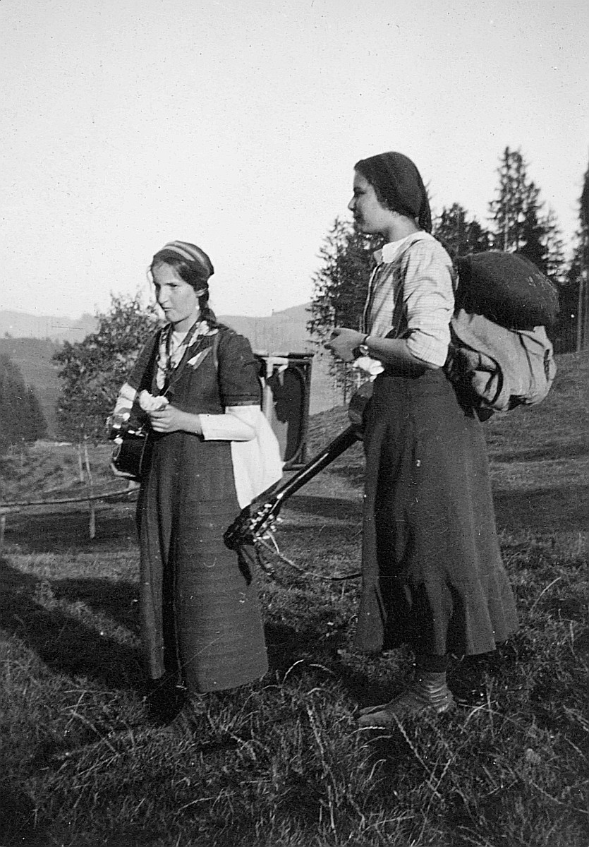 Zwei Wandervögel mit Gitarren und Rucksäcken stehen auf der Wiese (1912)