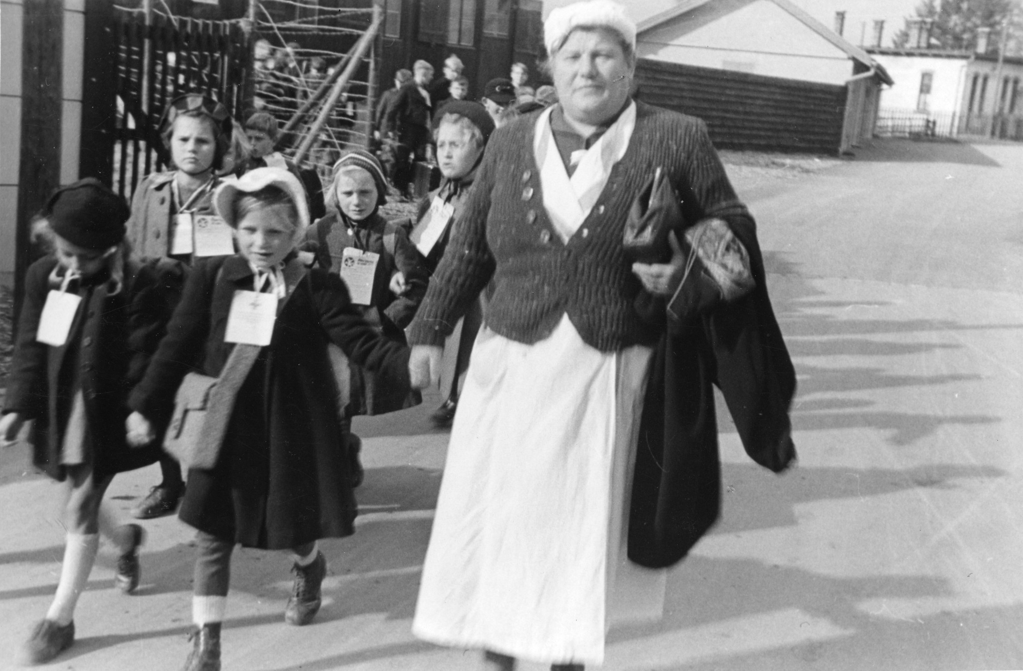 "Hasliberg, Oktober - November 1945. Wiener Arbeiterkinder kommen an."; Kinder gehen mit einer Betreuerin die Strasse entlang