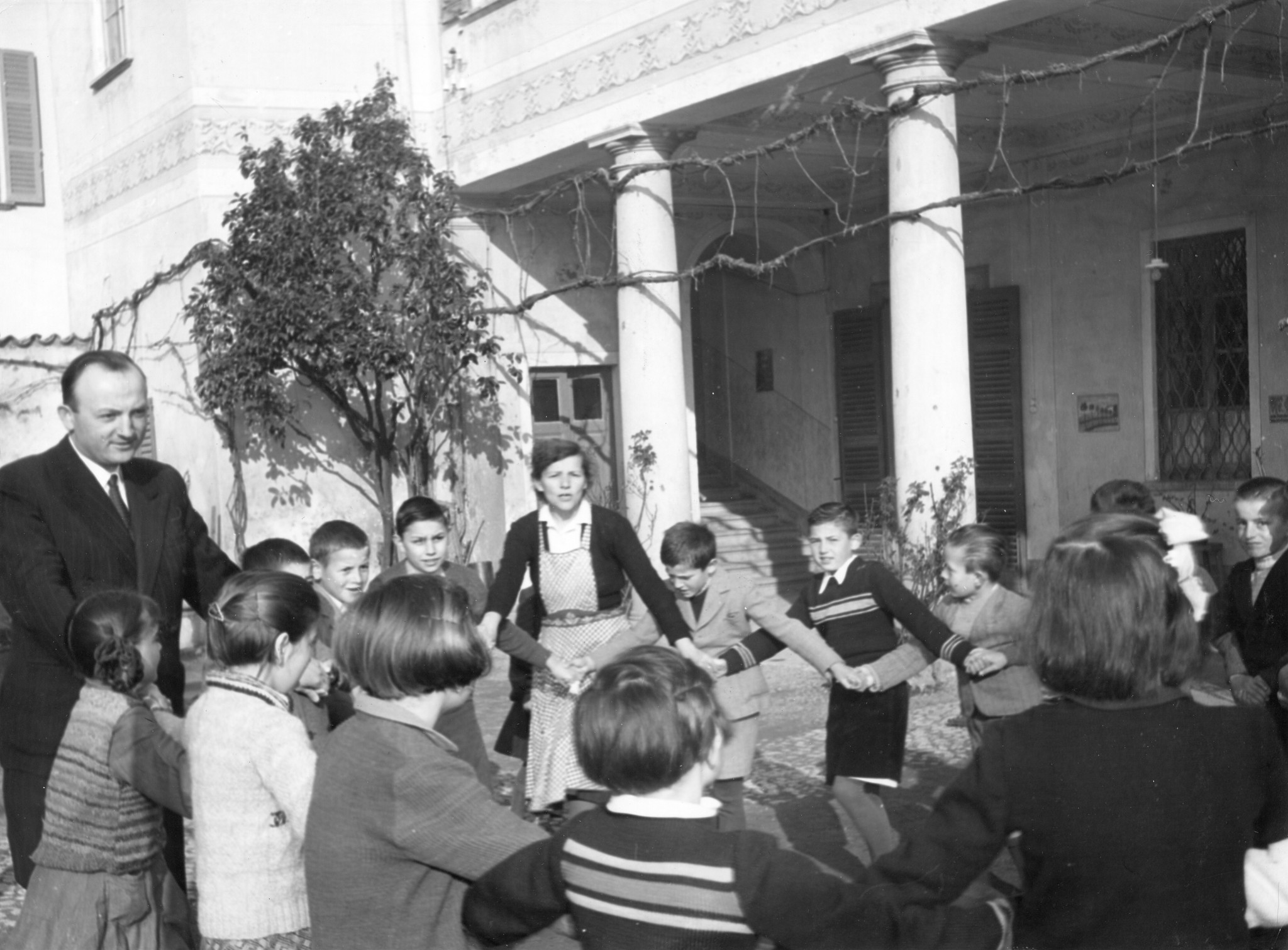 Betreuer tanzen mit den Kindern einen traditionellen jugoslawischen Tanz