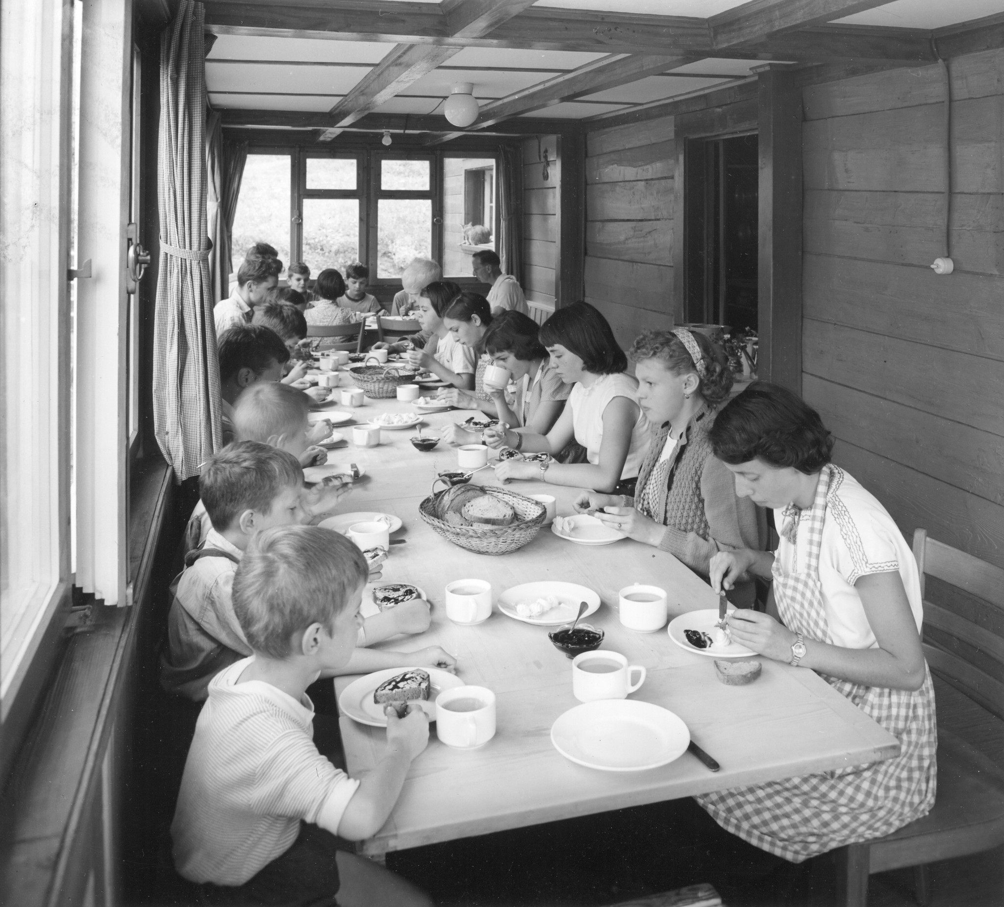 Kinder sitzen im Speisesaal und essen Butterbrote mit Konfitüre