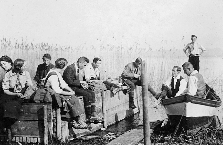 Wandervögel der Ortsgruppe Zürich sitzen auf einem Boot und auf einem Floss am See (1913)