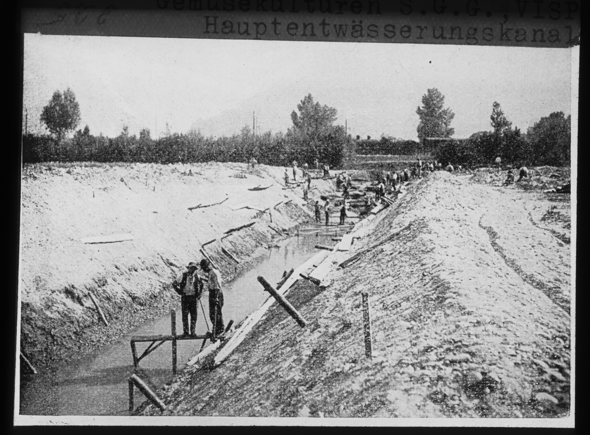 Dia: Arbeiter beim Ausbau des Hauptentwässerungskanals auf einem Feld der S.G.G. (Schweizerische Genossenschaft für Gemüsebau) in Visp.