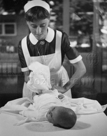 "Mütterberatung" - Beraterin beim Wickeln eines Säuglings; um 1965