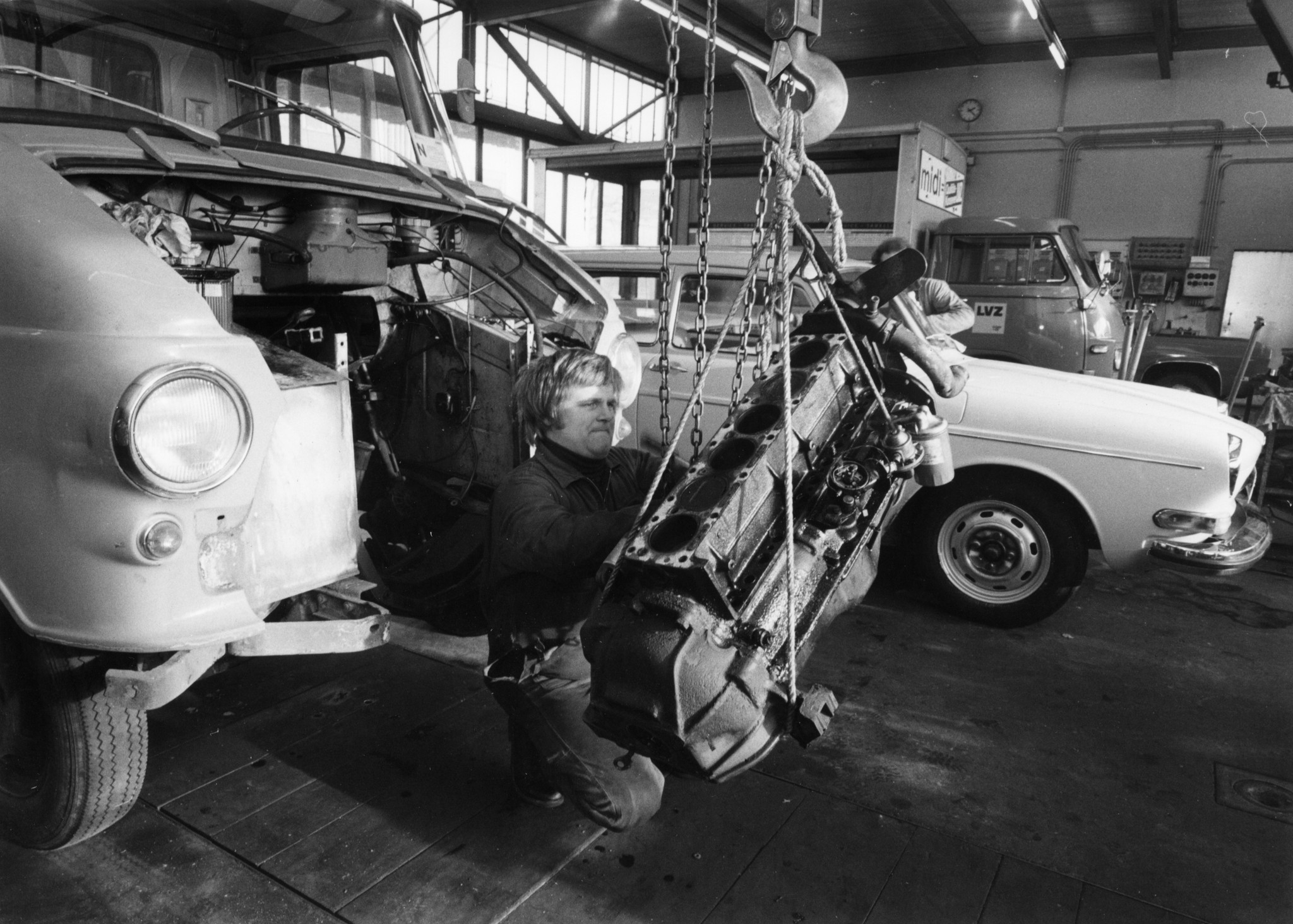 Automechaniker bei der Arbeit an einem aufgehängten Lastwagenmotor