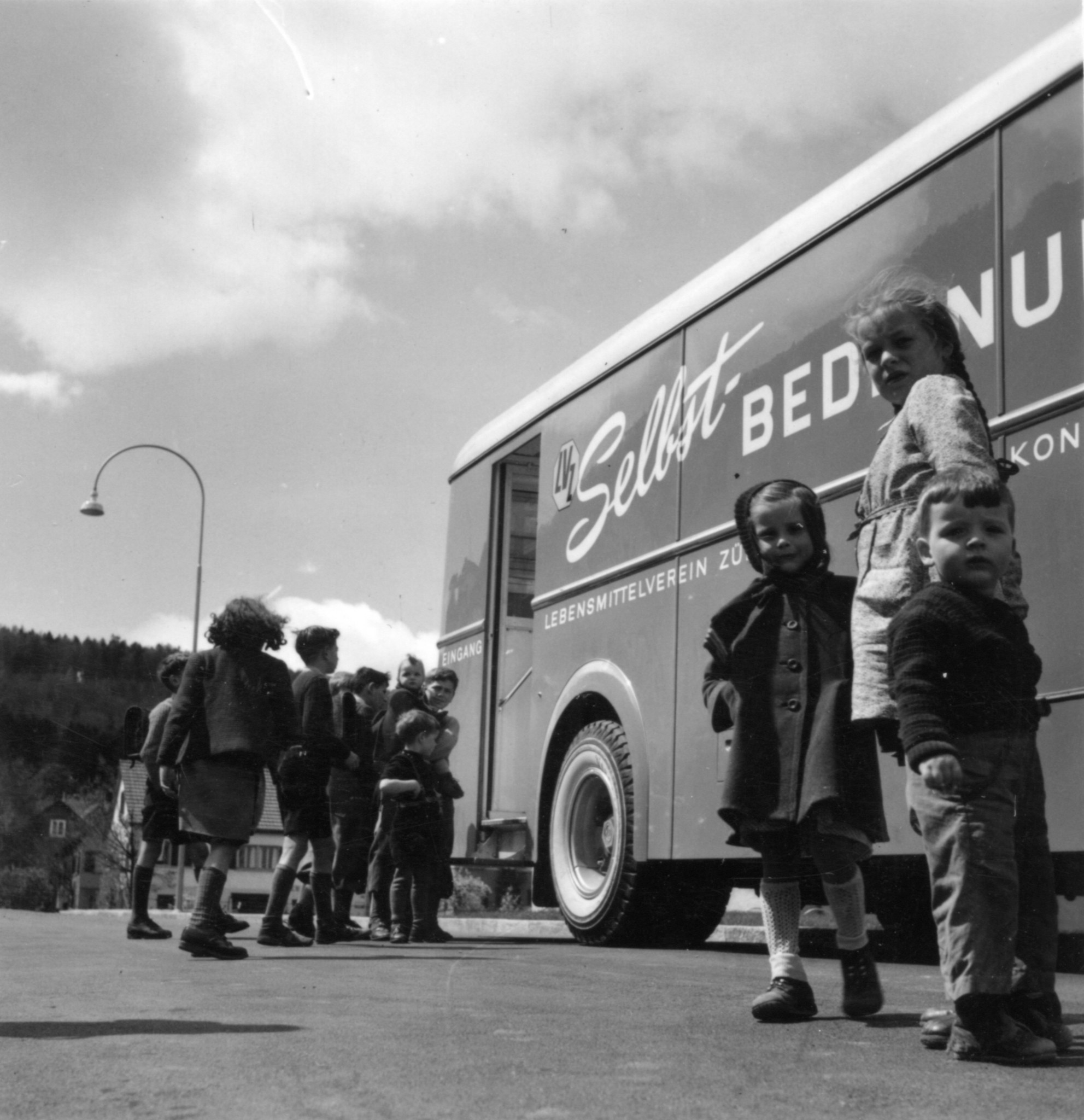 Kinder vor einem Verkaufswagen des Lebensmittelvereins Zürich