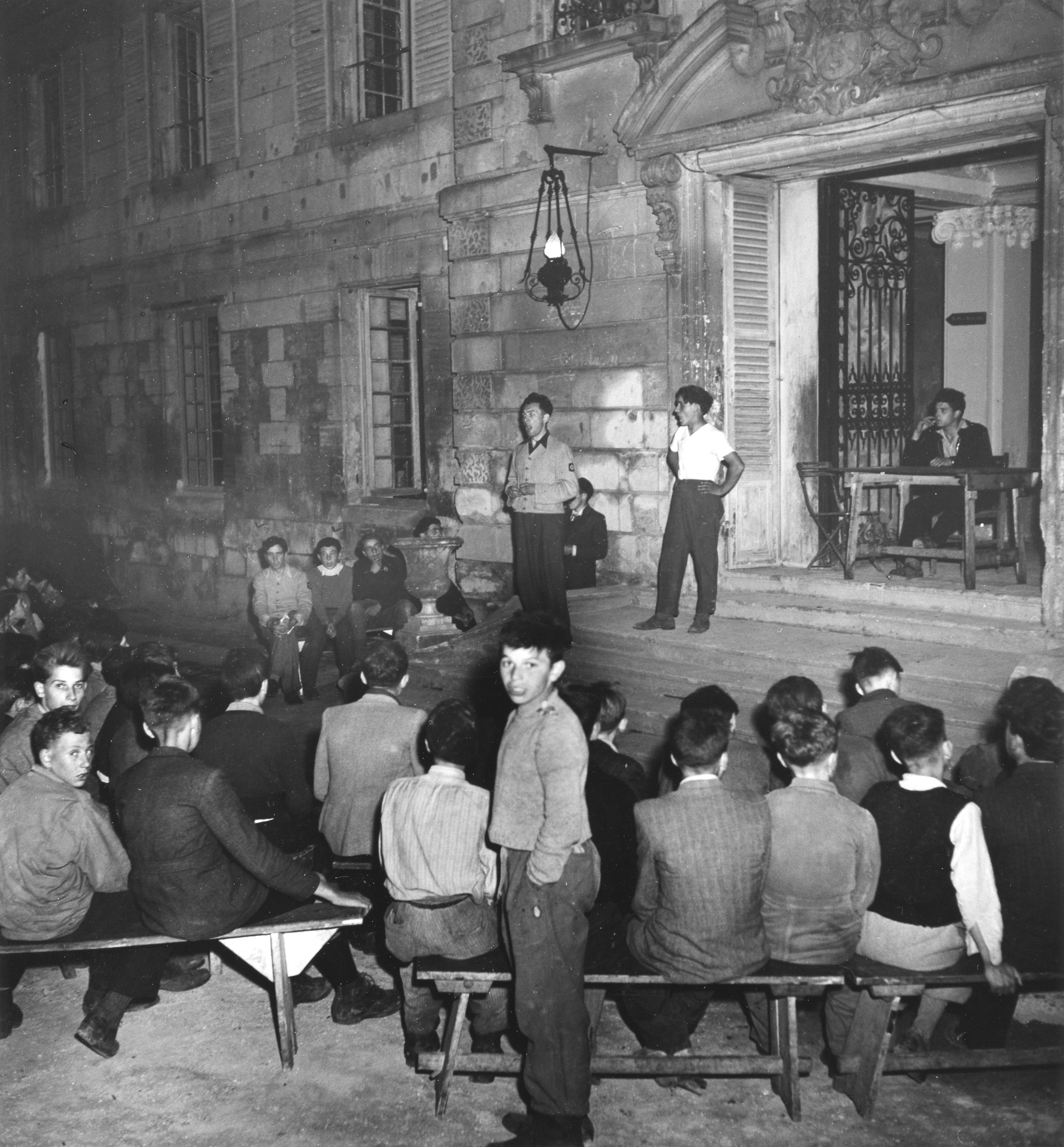 "Longueil-Annel (Ile de France) [eigentlich Picardie, Frankreich]", "In der Werkstatt", Singveranstaltung (?) unter freiem Himmel, [Schule für invalide, schwachbegabte und schwererziehbare Kinder und Jugendliche], vermutlich um 1950 (Nachkriegsz