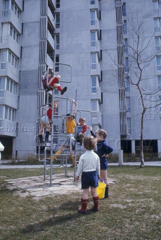 "Kletterstangen Winterthur" - spielende Kinder, dahinter ein Wohnblock; um 1975