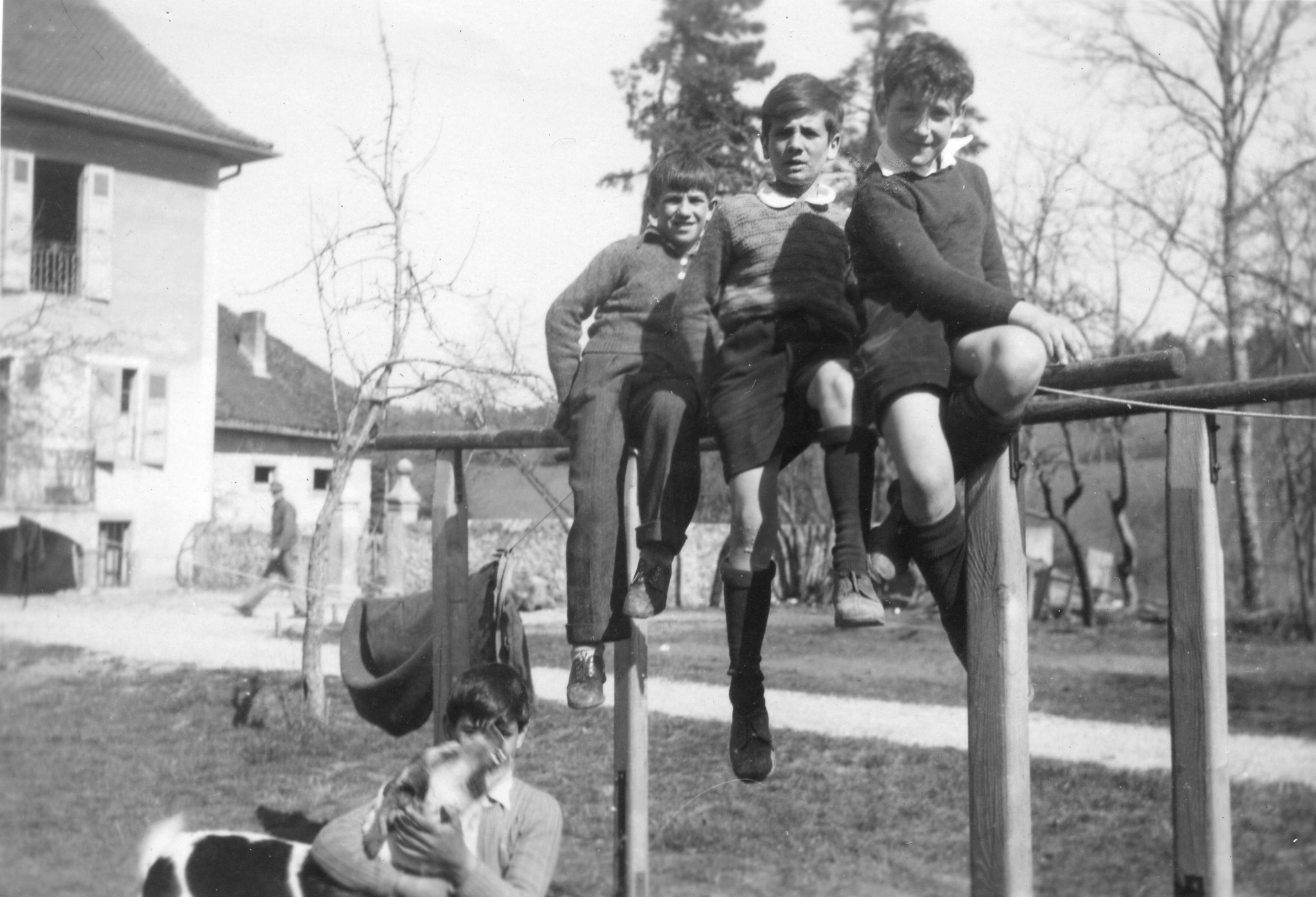 Drei Knaben sitzen auf einer Barre