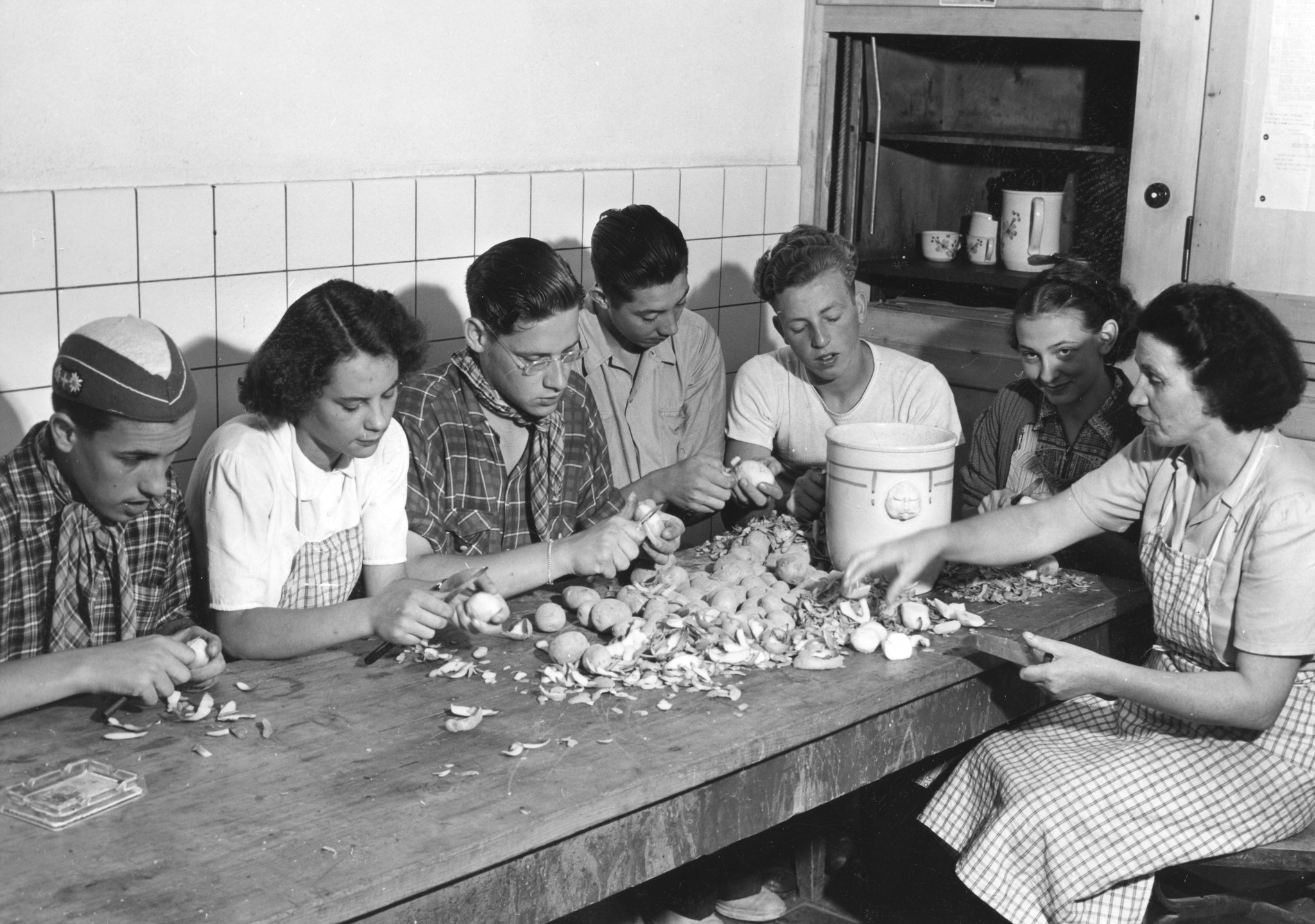 Jugendliche schälen in der Küche Kartoffeln