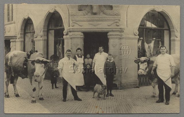 Metzger vor Metzgerei oder Schlachthaus, Rindvieh, Hund, Frau mit Schürze, Kinder, 1926 (Poststempel)