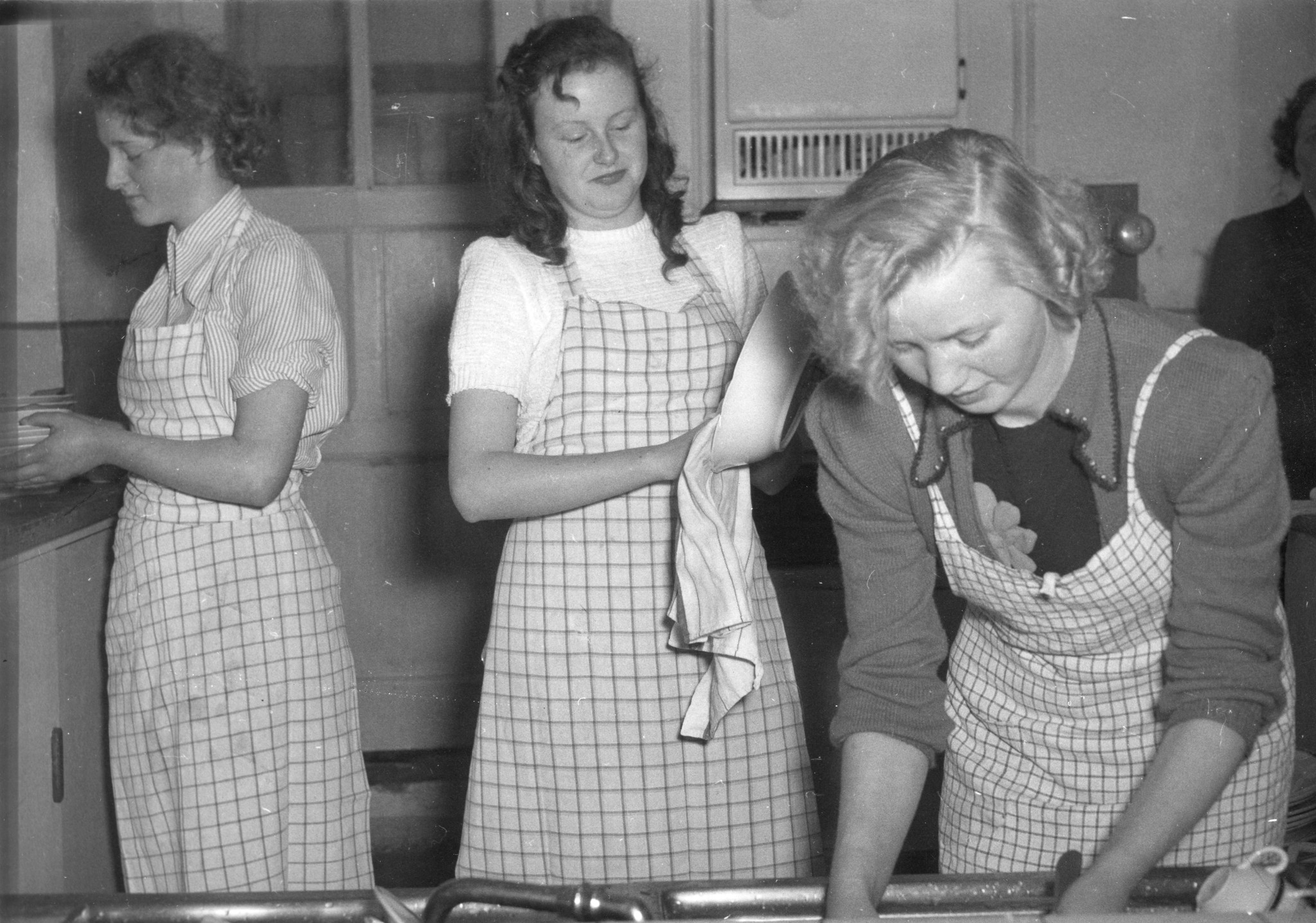 "Cavigliano - Haushaltungskurs für deutsche Flüchtlingsmädchen vom Dezember 1950 bis Februar 1951", Junge Frauen beim Spülen und Trocknen (Geschirr)