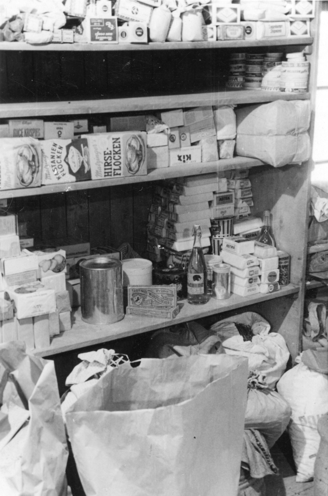 "Aus dem Sammellager Brauerstrasse, 1946"; Regale sind mit Spenden gefüllt