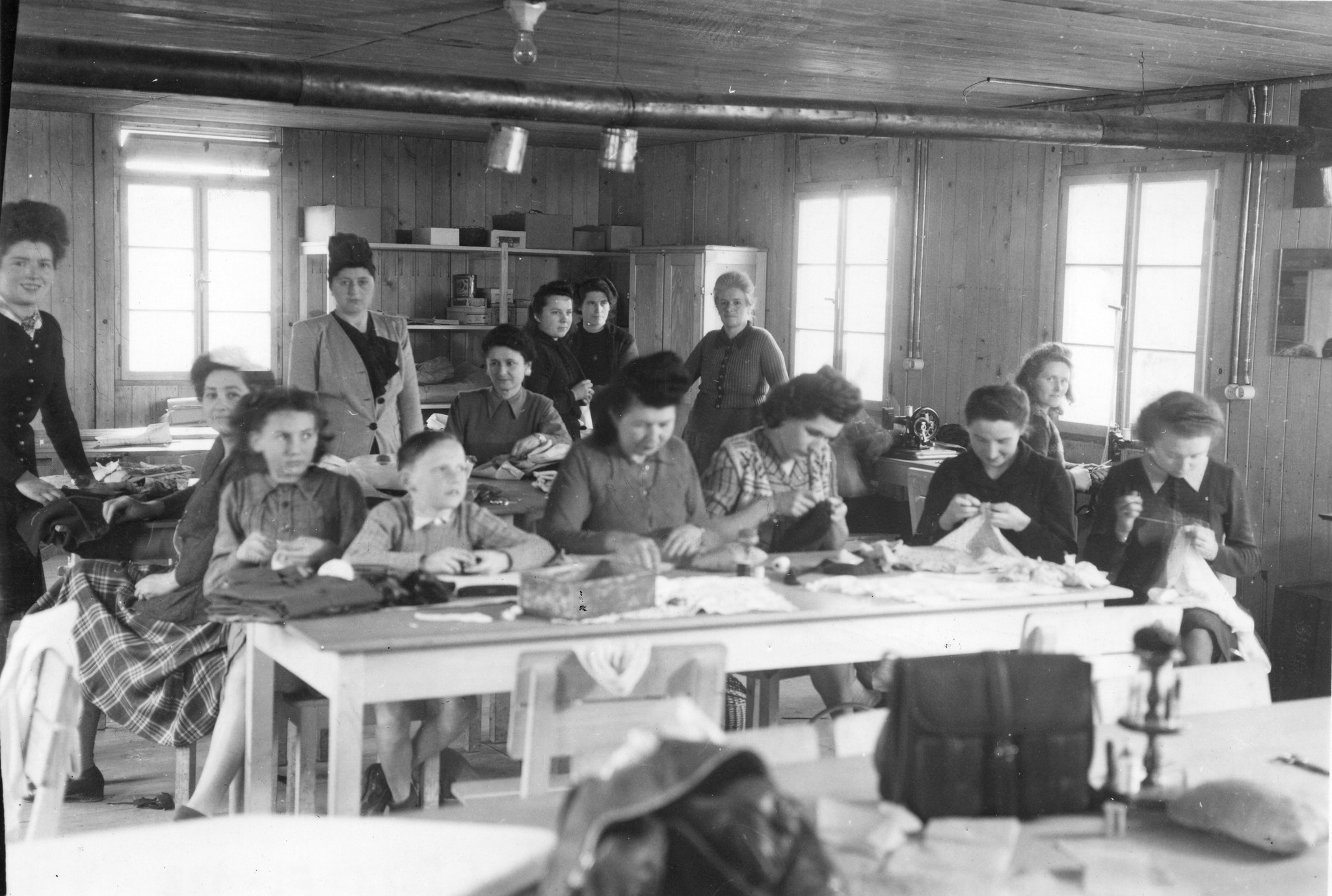 "Saint-Lô, une réunion de couture à l'ouvroir.", ganz links: Jeanne Mirabel (ehrenamtliche Helferin), vermutlich um 1946, [Sozialzentrum des SAH, "Don Suisse", "Ouvert à toute la population de St-Lô"]