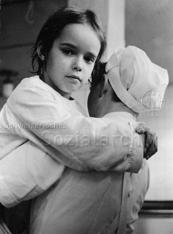 "Asthma" - Mädchen in den Armen einer Krankenschwester; um 1970
