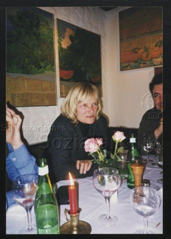 Abendessen, eine Person im Fokus, drei Rosen in Weinglas, Kerze, rechts: Justin Hoffmann