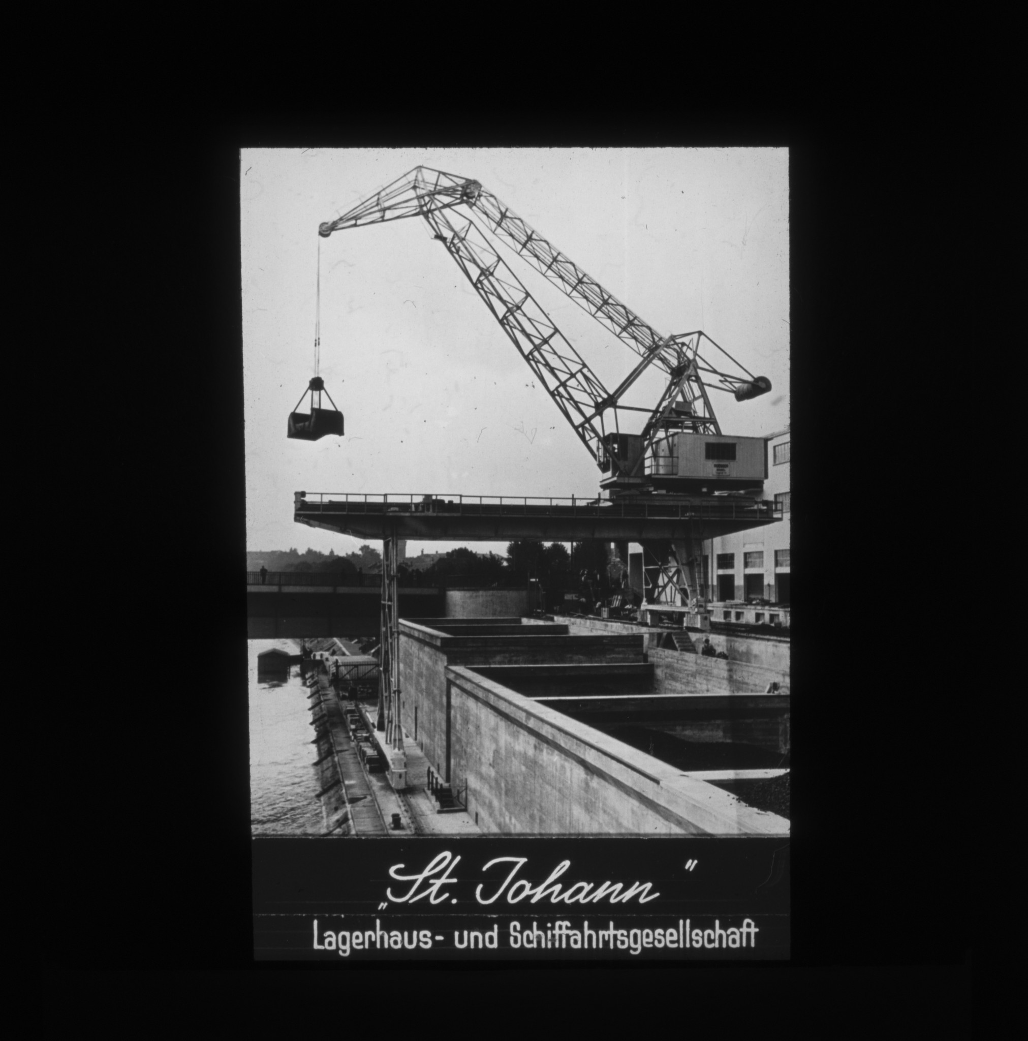 Dia: Kran mit Last an Flussufer: ""St. Johann" Lagerhaus- und Schiffahrtsgesellschaft".