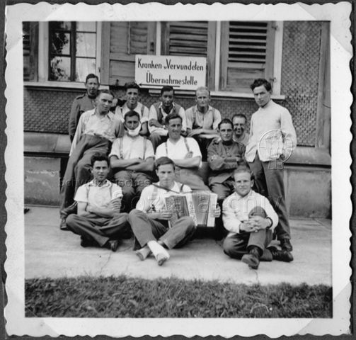 Album Alfred Brauchli, Teil 1/3: 699 Tage Aktivdienst 1939-1945 als Sanitätssoldat bei der Sanitätskompanie I/​7, Thurgau:Alfred Brauchli (vorne rechts) - Gruppenfoto vor der Kranken-/Verwundeten-Übernahmestelle, vermutlich während Aktivdienst 1940/1941