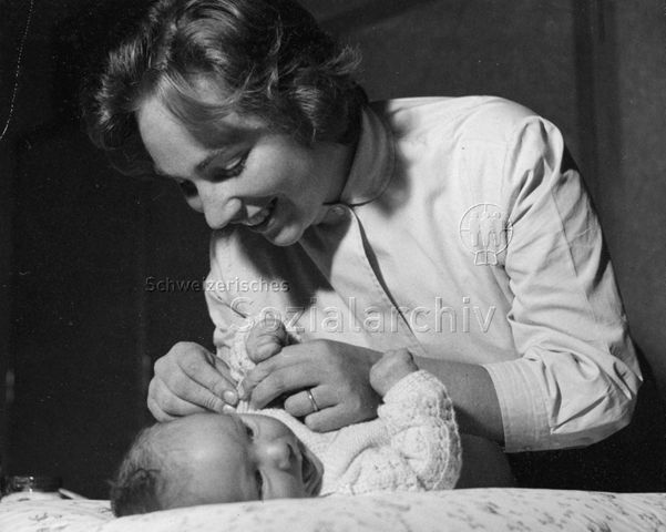 "Mütterberatung" - Mutter beim Ankleiden Ihres Säuglings; um 1960