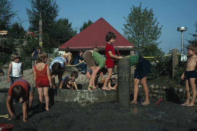 "Sansspielplatz St. Anton/Luzen, Selbstbau" - Kinder beim Spielen mit Sand und Wasser; 1975