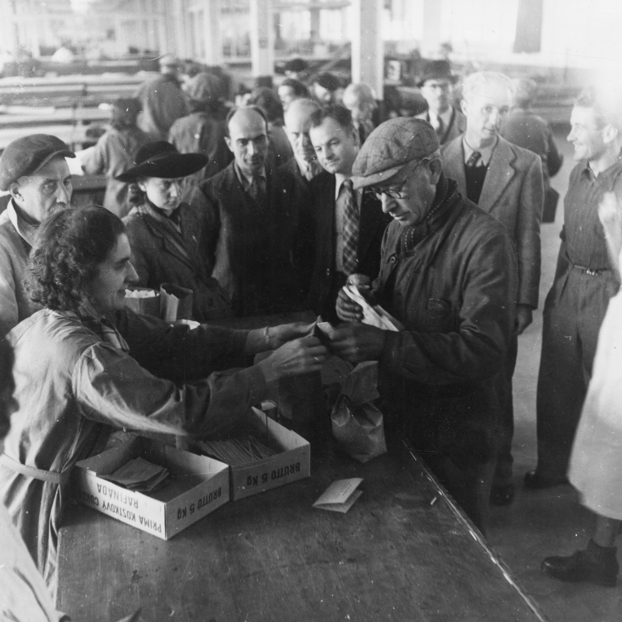 "Lyon, Oktober 1944. Wertvolle Zusatznahrung für unterernährte Arbeiter." "Französische Arbeiter und Arbeiterinnen der Fabriken Berliet nehmen Lebensmittel des SAH in Empfang." Zweite von links: vermutlich Germaine Ribière (mit dem Hut)