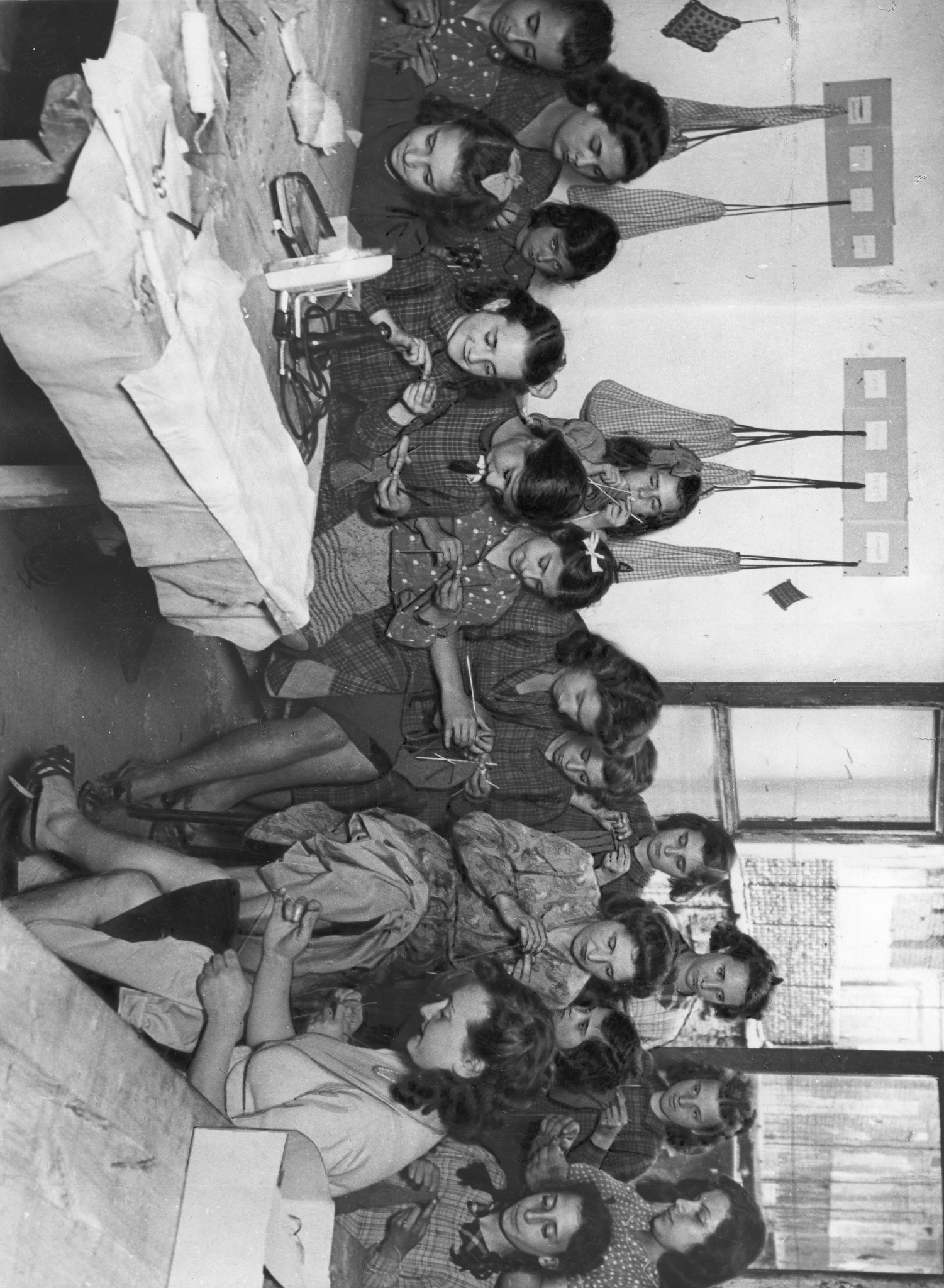 "Torino, Doposcuola, 1947 - Stricken und Häkeln - das Material ist von der SSP"; Mädchen und Frauen sitzen in einem Raum und stricken