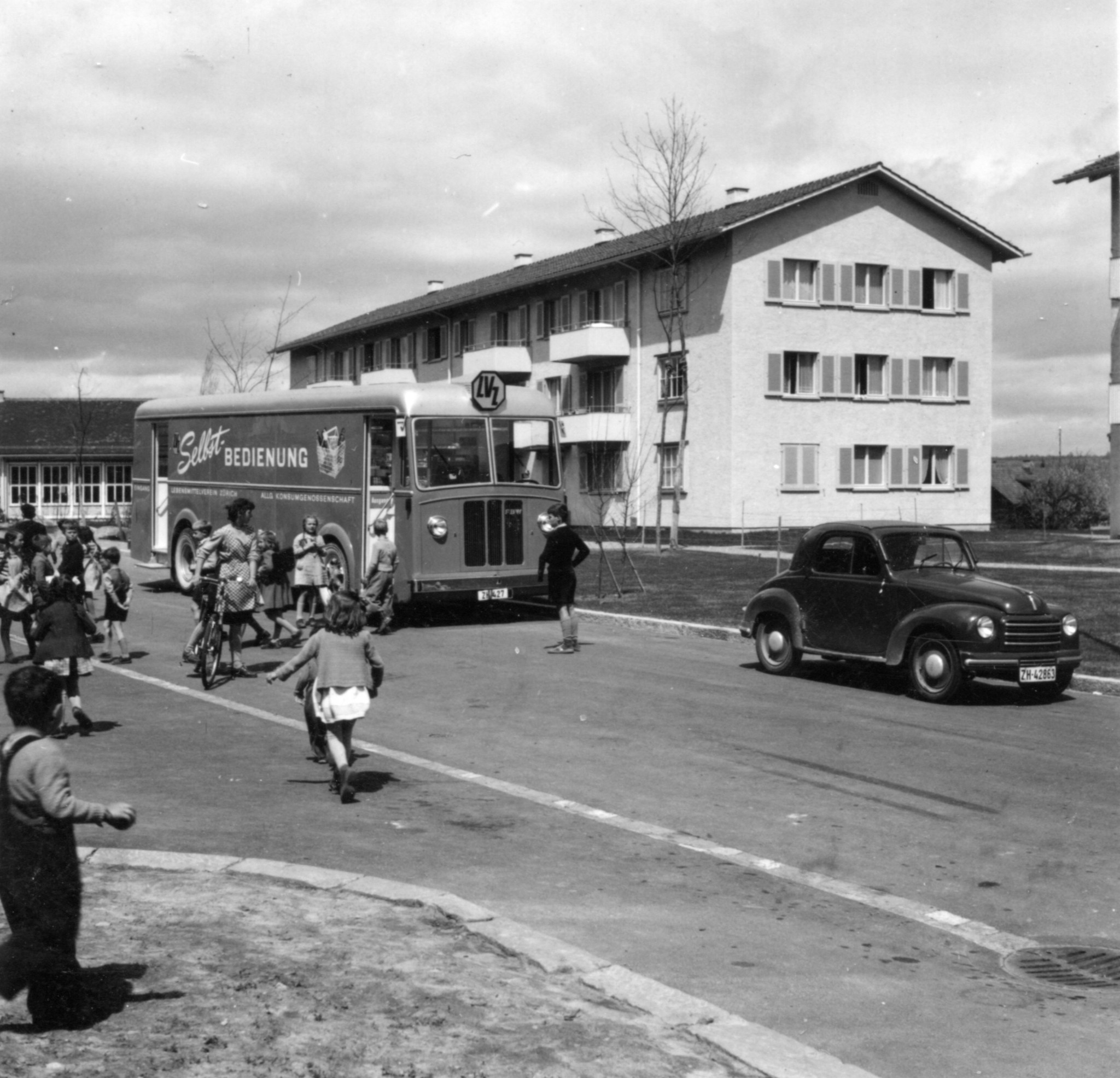 Kinder und Passanten vor einem Verkaufswagen des Lebensmittelvereins Zürich