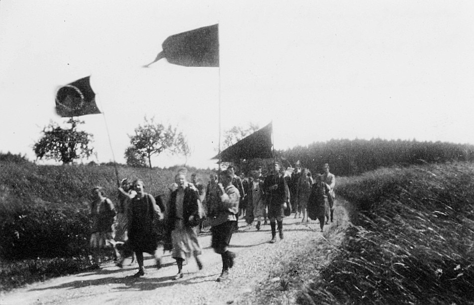 Wandervogel-Landsgemeinde in Agasul - Zug zur Kyburg: Wandervögel, zum Teil eine Flagge tragend, laufen auf der Strasse (1927)
