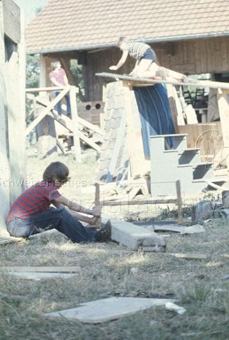 "Bauspielplatz Binningen" - Junge beim Zersägen eines Holzbalkens; um 1975
