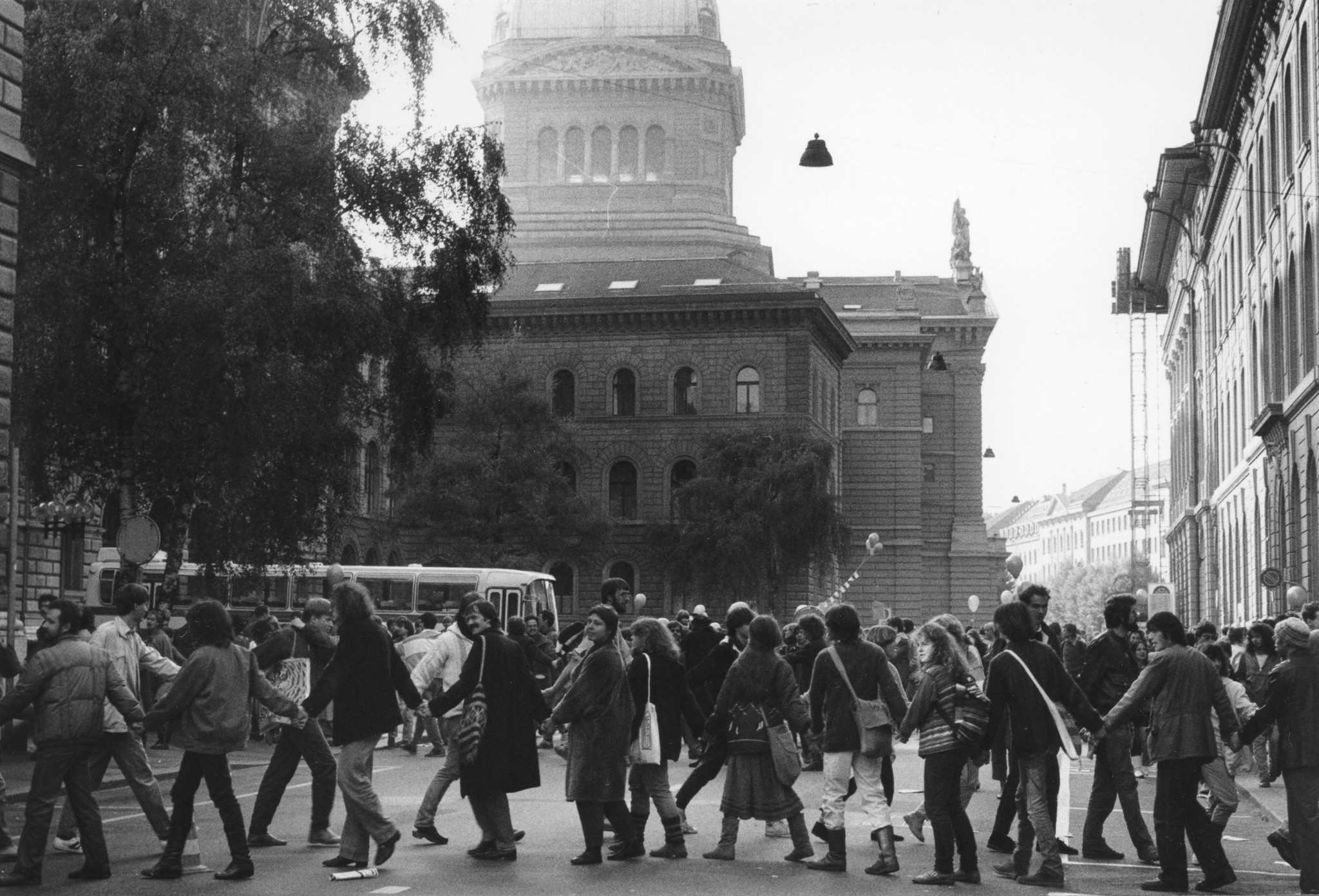 Friedensdemonstration organisiert von der SAH im November 1983; eine Menschenkette versperrt die Strasse vor dem Bundeshaus in Bern