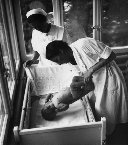 "Mutter + Kind" - Hebamme steht daneben; um 1950