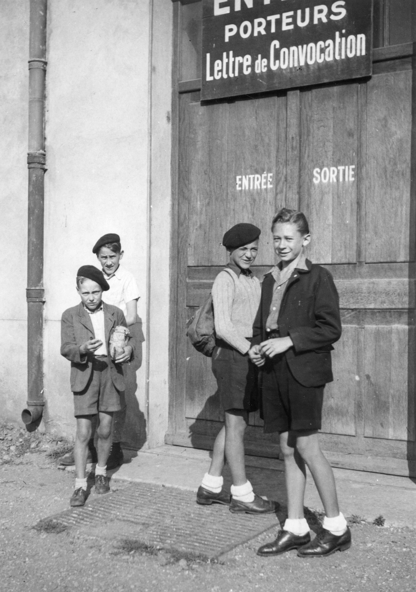 "Lyon 1945. Vor der Abfahrt der Buben in die Ferienkolonie Berliet." Schild: "Entrée Porteurs Lettre de convocation"