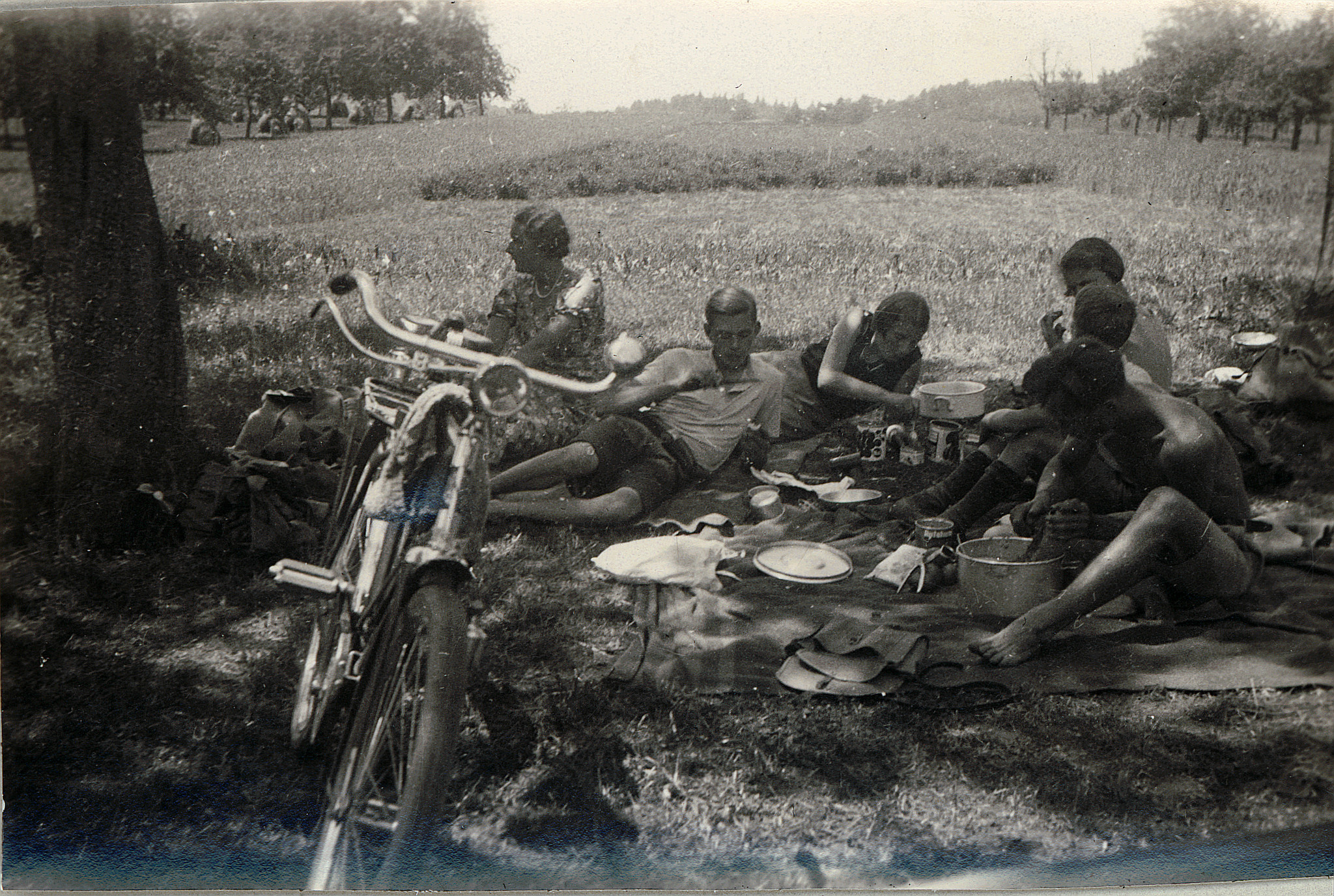 Wandervogeltreffen: EM 5 - Wandervögel sitzen auf der Wiese bei einer Mahlzeit - Velo (1930)