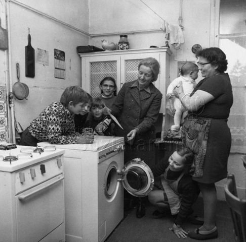 Zwei Frauen und Kinder in Küche begutachten Waschmaschine; um 1965