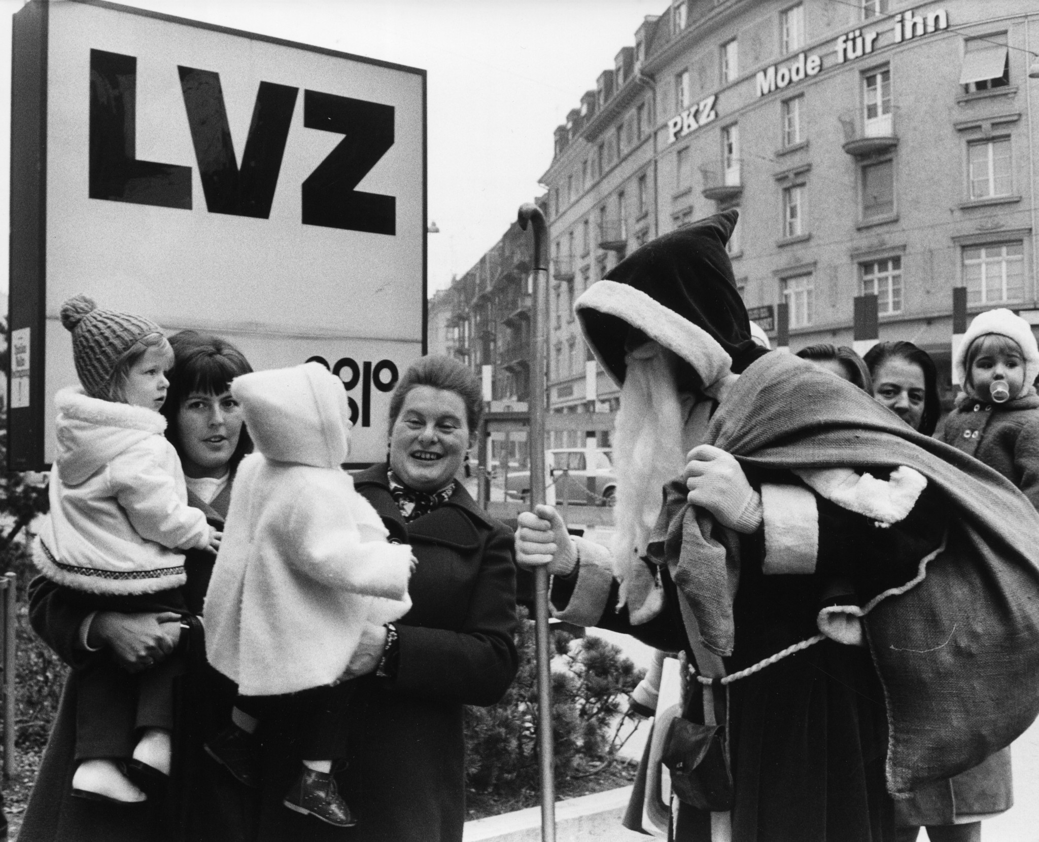 Nikolaus mit Erwachsenen und Kindern vor einer Supermarkt-Filiale