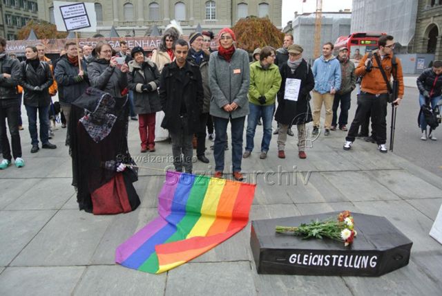 Kundgebung in Bern gegen die Familieninitiative der CVP (16.11.2013, Bern) – Sarg: Gleichstellung, verschleierte Person mit Regenbogenflagge, "Depuis 30 ans je paie les mêmes impots que les héteros ! Aujourd'hui, je veux les même droits ! Un point c'est tout !" (rechts), "NEIN !!! Zur Diskriminierung in der Verfassung / NON !!! Aux discriminations dans la Constitution" (links)