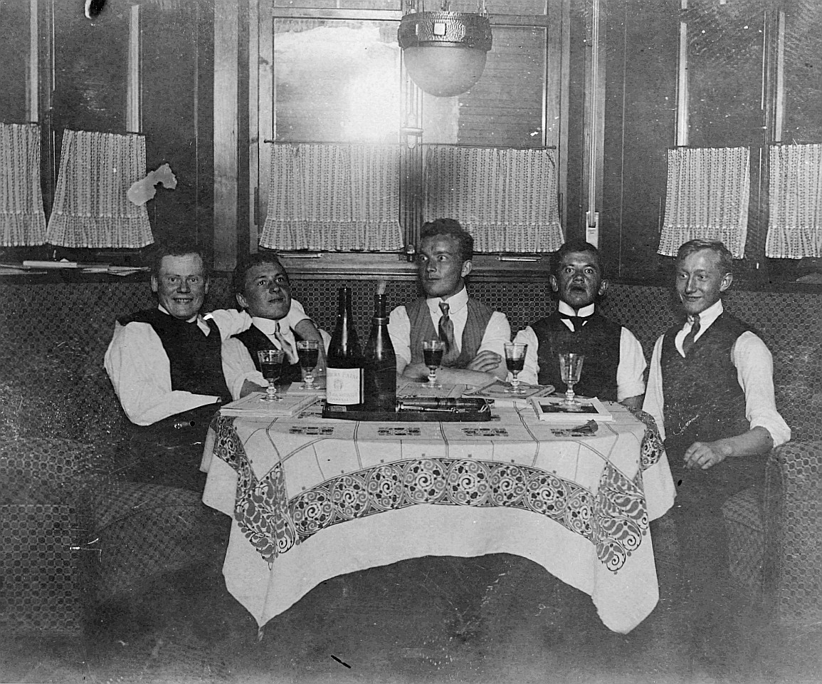 Mitglieder der Wandervogel-Ortsgruppe Aarau-Stadt sitzen am Tisch und haben vor sich alkoholische Getränke (1914) - "Einige Mitglied