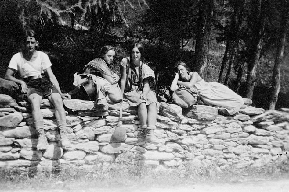 2. Sommerfahrt: Wandervögel mit Rucksäcken sitzen auf einem Steinmauer (1929)