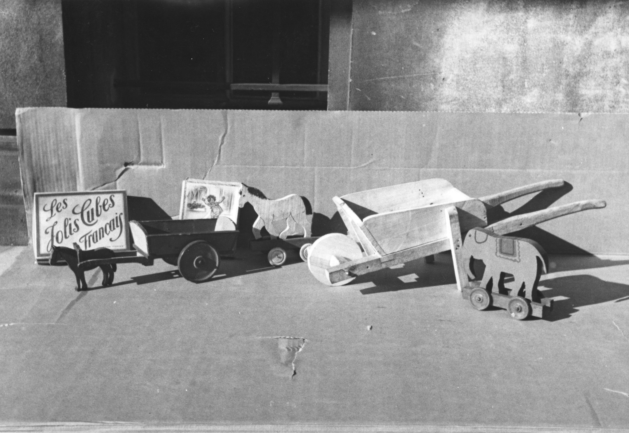 "Spielzeuge für Franzosenkinder", Spielzeugwagen mit Eseln, Rollelefant und Schubkarre, Spielzeug: "Les Jolis Cubes Français", um 1950 (Nachkriegszeit)