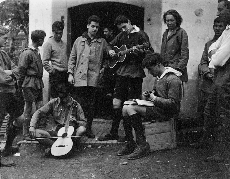 Wandervogel-Landsgemeinde in Kimenhof bei Embrach - Wandervögel spielen Gitarre und Ukulele; andere Wandervögel zuschauend (Pfingste