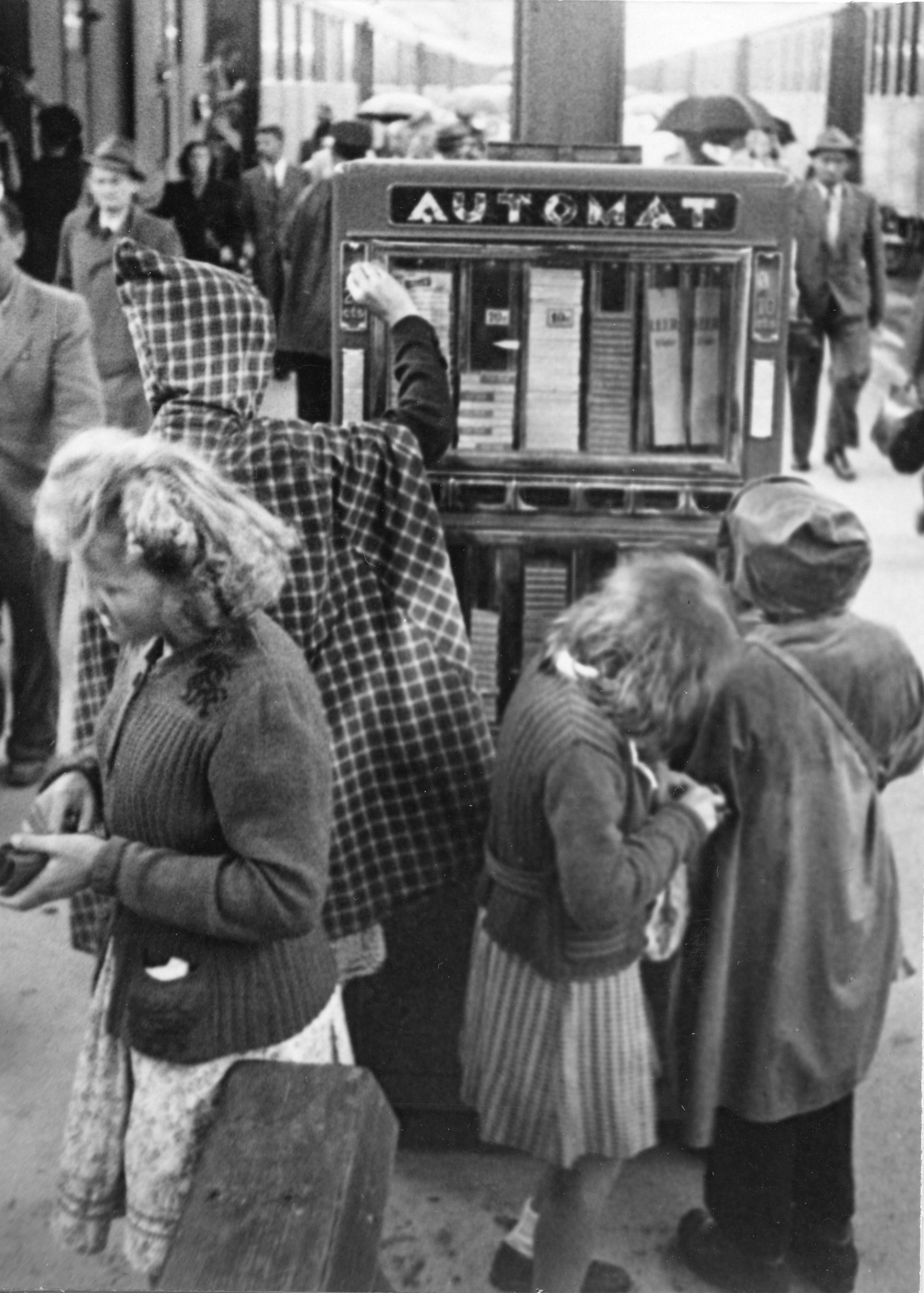 "Warte, warte..." Kinder stehen am Bahnhof vor einem Automaten und kramen in ihren Geldbörsen
