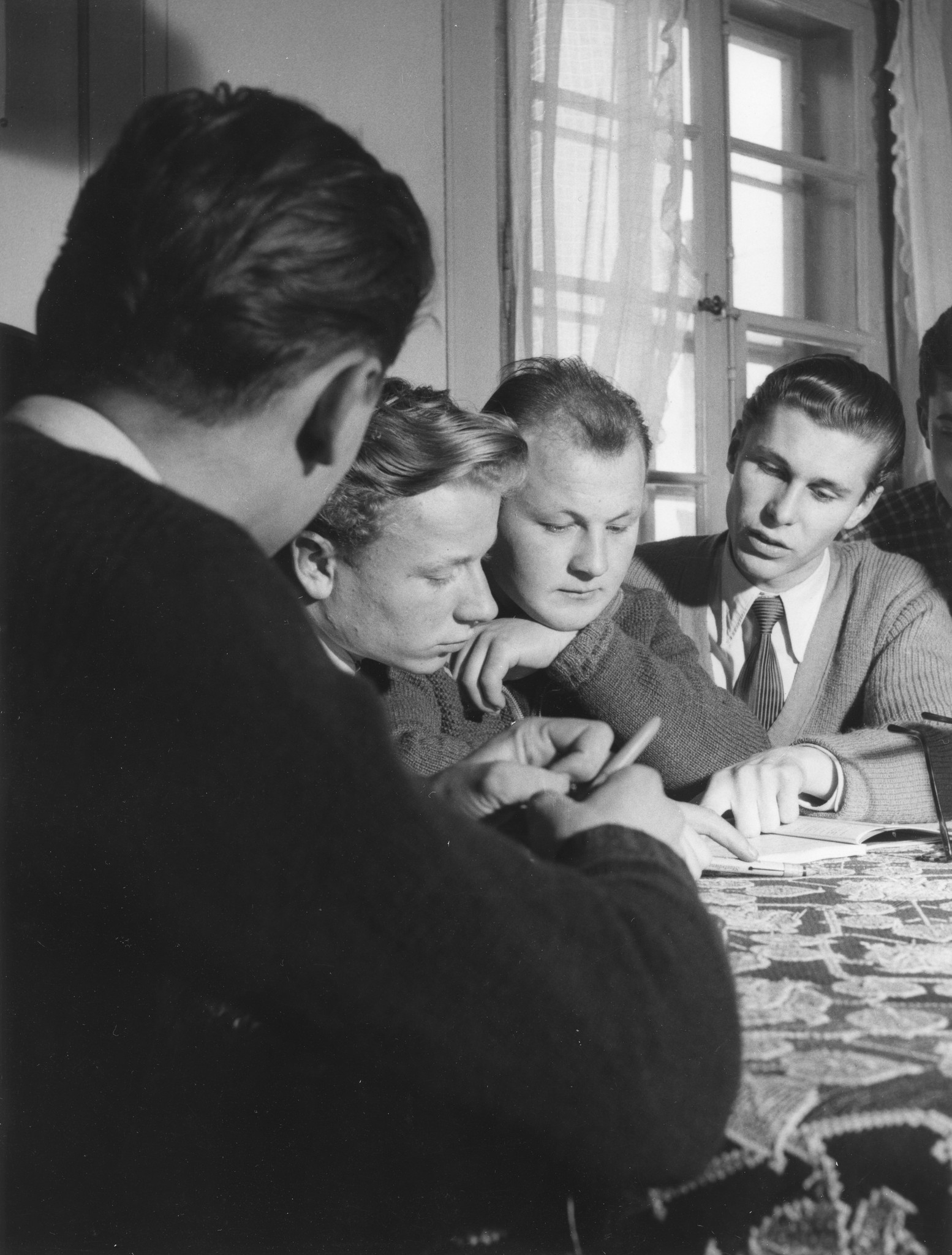 Erholungsaktion für jugendliche deutsche Flüchtlinge im Ferienhaus Lindenbühl 1952/1953; Jugendliche lesen zusammen ein Buch