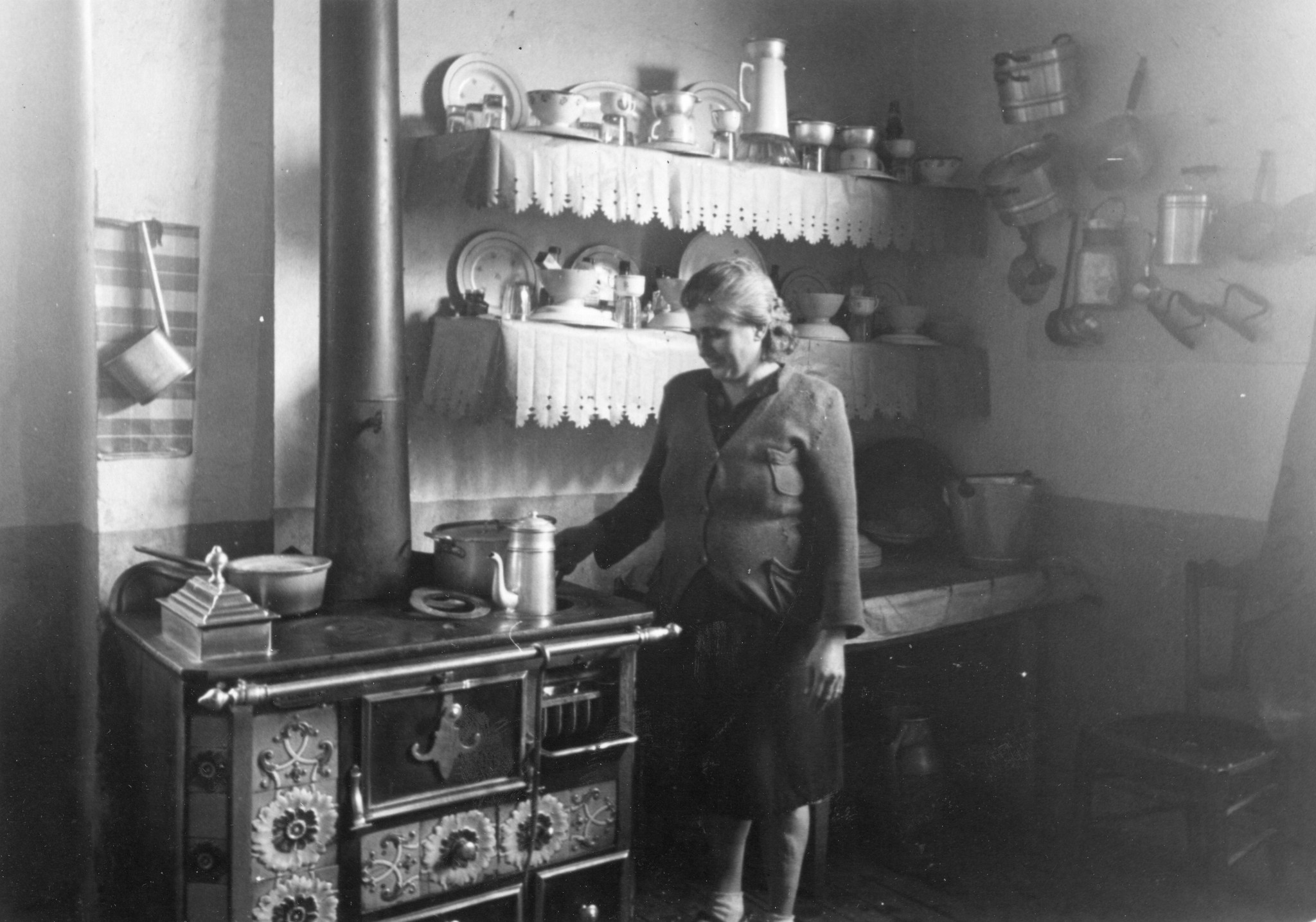 "Saint-Etienne, 1945. Wie hat Frau Grenados die Küchenecke geschmack- und phantasievoll hergerichtet! An der Wand hängen die Pfannen aus dem Aermo-Möbelpaket."