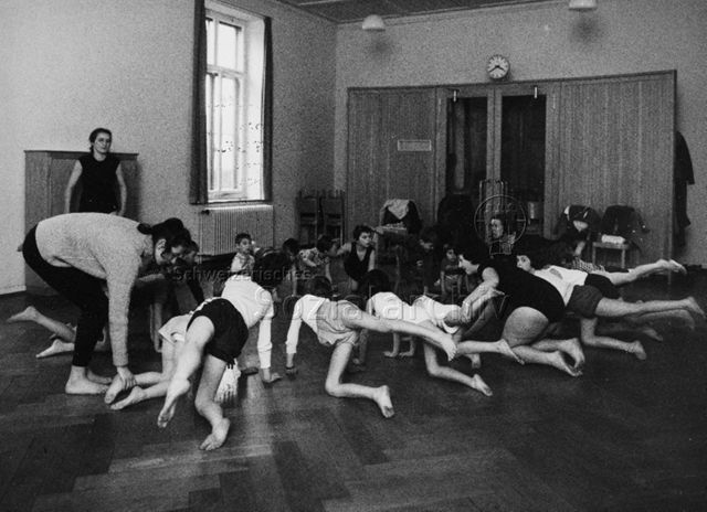 Turnen - Kinder bei einer Beweglichkeitsübung; um 1970
